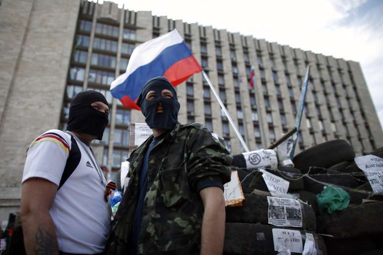 <p>Manifestantes pr&oacute;-R&uacute;ssia&nbsp;montam guarda perto de barricada montada em frente a um edif&iacute;cio do governo na cidade de&nbsp;Donetsk, em 23 de abril</p>