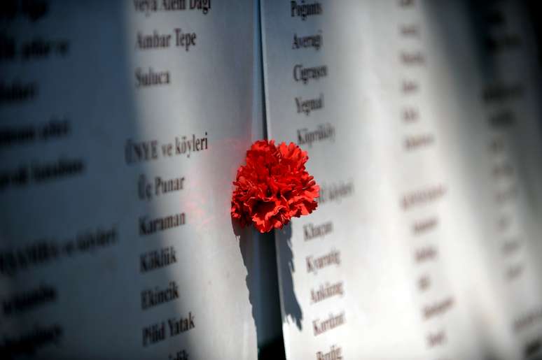 <p>Um cravo é depositado sobre uma lista com as vítimas do genocídio que completa 99 anos, nesta quinta-feira</p>