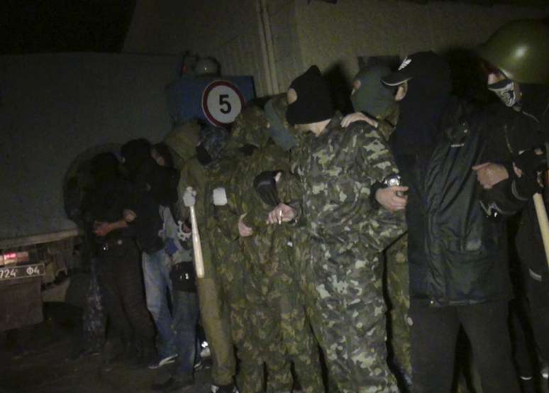 Foto de 16 de abril: manifestantes pró-Rússia fazem guarda em base militar de Mariupol, Ucrânia