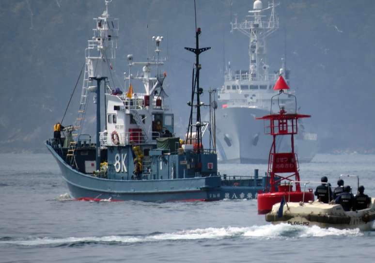 Sob olhar da Guarda Costeira, navio baleeiro deixa o porto de Ayukawa para nova temporada de caça