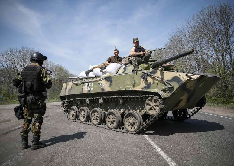<p>Soldados ucranianos sentam&nbsp;em cima de um ve&iacute;culo blindado em um posto de controle, nos arredores da cidade de Slaviansk, neste domingo, 27 de abril</p>