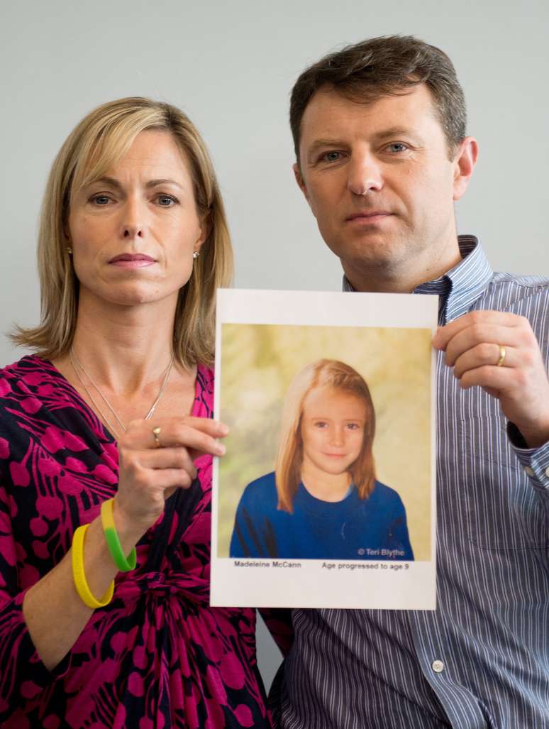 <p>Pais de Madeleine McCann posam com retratro que mostra como a menina desaparecida estaria cinco anos após o crime, em 2 de Maio de 2012 </p>