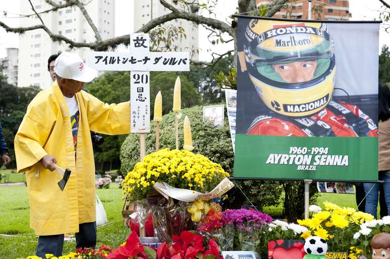 <p>Chiquinho Japonês (de amarelo) homenageou tricampeão com crucifixo em japonês e espigas de milho ao lado de lápide</p>