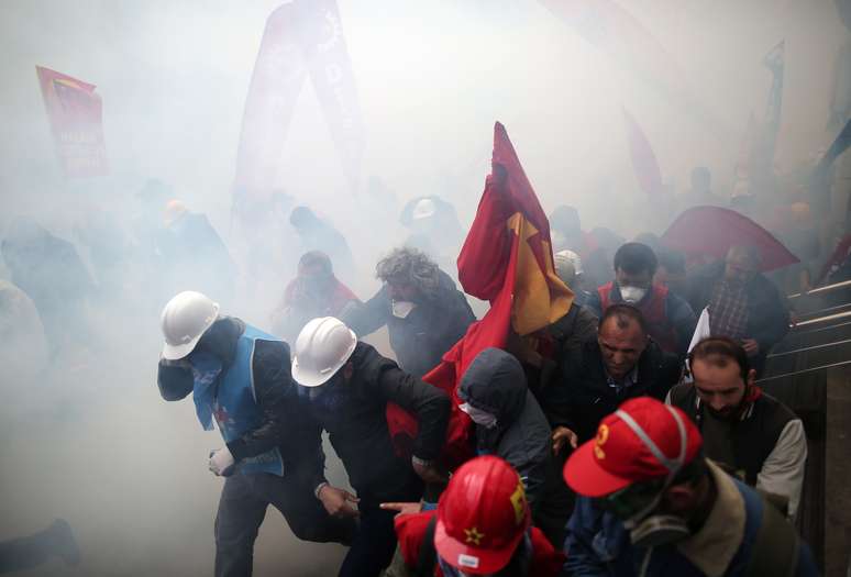 <p>Pessoas correm e se protegem, quando&nbsp;a pol&iacute;cia de choque usa canh&otilde;es de &aacute;gua e g&aacute;s lacrimog&ecirc;neo para dispersar milhares de manifestantes que tentam chegar &agrave; principal pra&ccedil;a de Istambul, a&nbsp;Taksim square,&nbsp;para celebrar o 1&ordm; de maio em Istambul, Turquia</p>