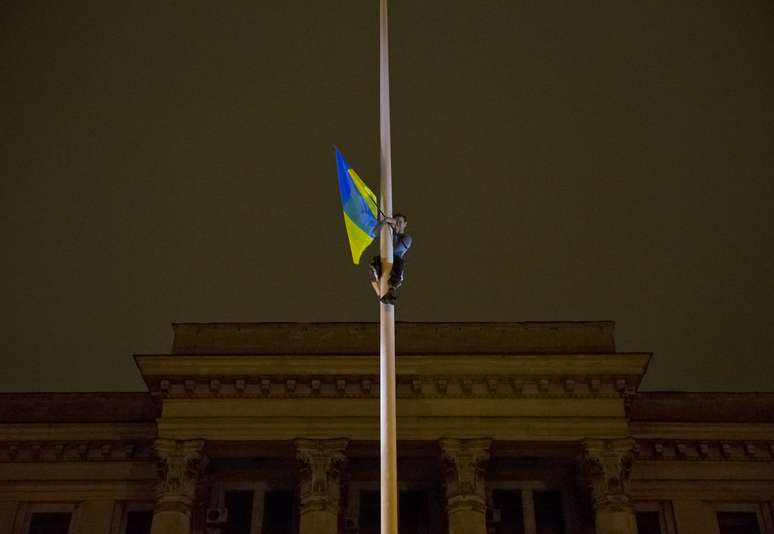 <p>Uma bandeira ucraniana foi hasteada em frente ao prédio que pegou fogo em 2 de maio, matando manifestantes pró-russos</p>