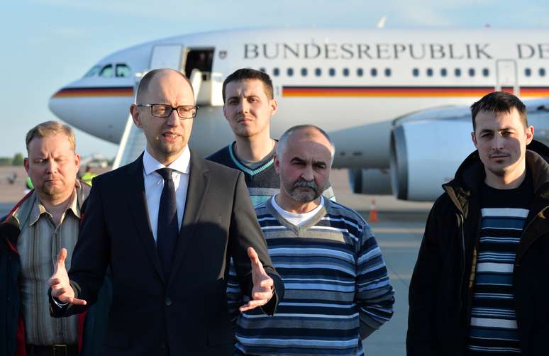 <p>Primeiro-ministro da Ucrânia, Arseniy Yatsenyuk fala com membros da equipe da OSCE libertados em 3 de maio, no aeroporto Boryspil em Kiev. Yatsenyuk disse à BBC que investigação independente vai apurar tragédia em Odessa </p>