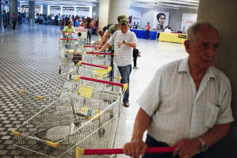 <p>Clientes fazem fila para fazer compras em supermercado estatal em Caracas, em 2 de maio</p>