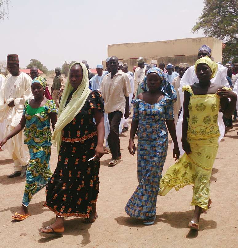 <p>Foto de 21 de abril mostra quatro alunas da escola secundária do governo de Chibok, que foram sequestrados por homens armados, caminhando junto com suas famílias, na Nigéria</p>