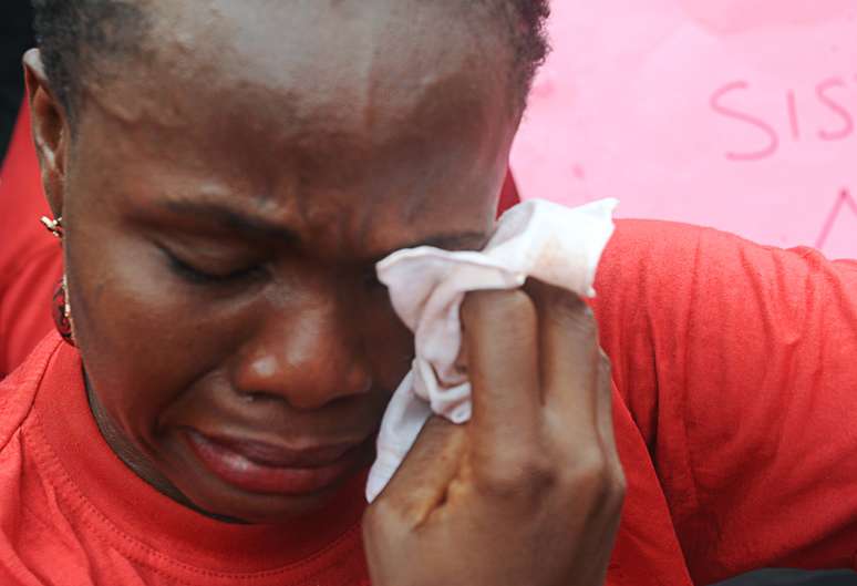 <p>Uma das mães das meninas sequestradas na escola em Chibok enxuga as lágrimas durante um comício de grupos da sociedade civil que pressionam para a liberação das meninas em Abuja, 6 de maio, antes do Fórum Econômico Mundial</p>