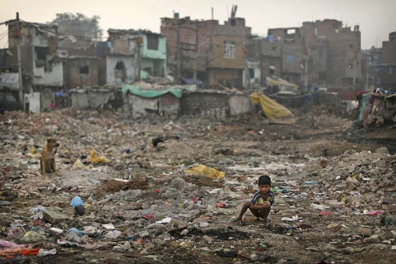 <p>Menino indiano defeca ao ar livre em um bairro de Nova Déli, em novembro de 2012. 600 milhões de pessoas defecam em público no país</p>