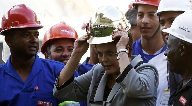 A presidente Dilma Rousseff ganha capacete dourado de operários na Arena Corinthians durante visita nesta quinta-feira.