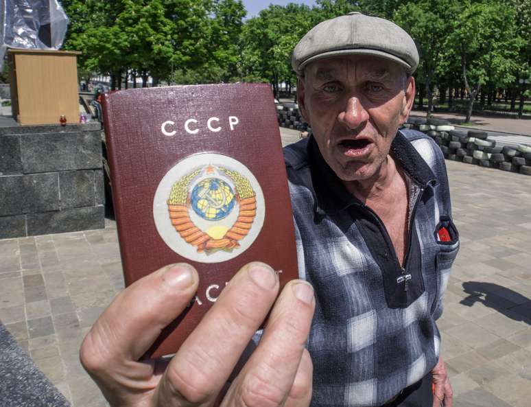 Homem mostra antigo passaporte da União Soviética na véspera do referendo de independência em Lugansk
