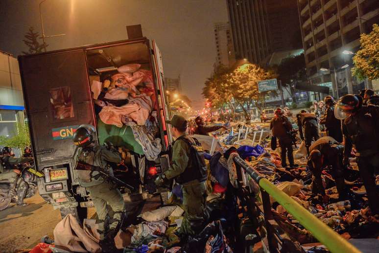 <p>Soldados da Guarda Nacional Bolivariana colocam em caminhões pertences de manifestantes que haviam se instalado em acampamentos em Caracas, em de 8 maio</p>