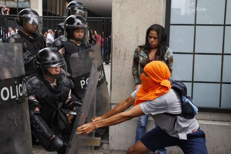 <p>Manifestante da oposição tenta enfrentar a guarda nacional durante um protesto contra o governo do presidente Nicolas Maduro, em Caracas</p>
