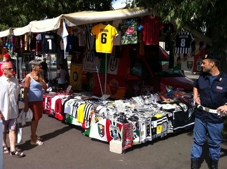 Ambulantes lucram com vendas de artigos fora do estádio, em Turim
