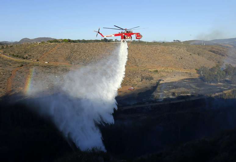 <p>Helicóptero despeja água em uma das áreas atingidas por incêndio, ao norte de San Diego, nesta terça-feira, 13 de maio</p>