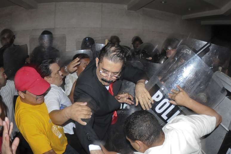 <p>Manuel Zelaya, ao centro é expulso à força pela polícia do edifício do Congresso, juntamente com outros membros de seu partido LIBRE, em Tegucigalpa, Honduras, na terça-feira, 13 de maio</p>