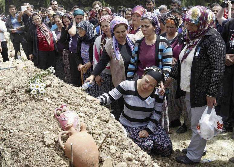 Mulheres acompanham o enterro de um mineiro morto no incêndio em uma mina de carvão, em um cemitério em Soma, na Turquia, nesta quinta-feira. 15/05/2014