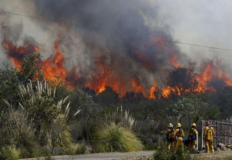 Bombeiros observam de perto as chamas, enquanto se preparam para proteger uma casa, em San Marcos, na região de San Diego, na Califórnia, Estados Unidos, nesta quinta-feira. 15/05/2014