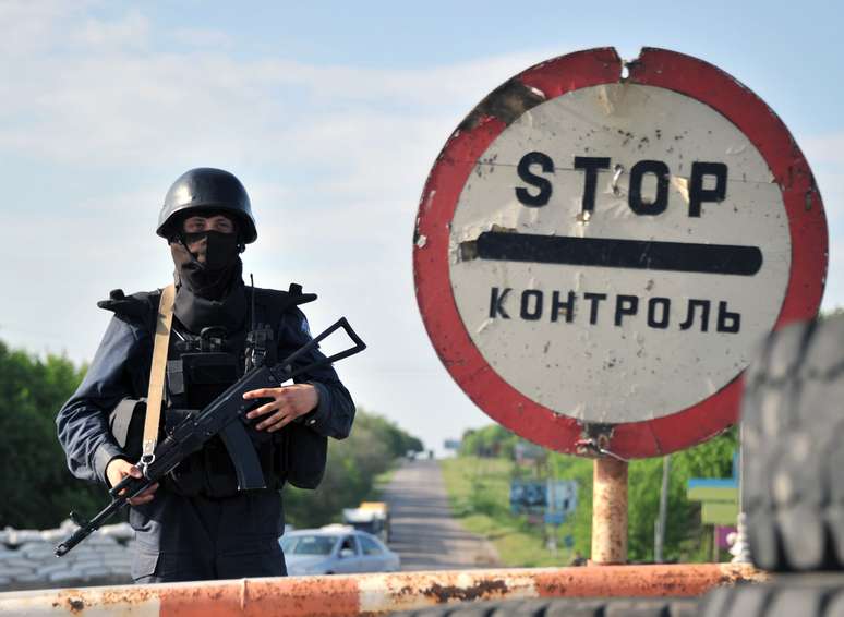 <p>Tropas ucranianas ficaram de guarda em um posto de controle na estrada perto da cidade oriental de Izum, região Donetsk; homens armados invadiram um quartel-general</p>