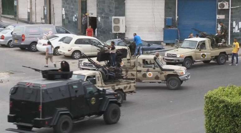 <p>Veículos com artilharia pesada das forças de segurança conjunta Tripoli aproximam-se do edifício do parlamento neste domingo</p>