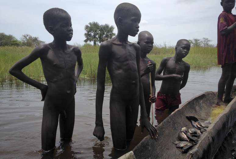 Meninos tentam vender peixes após a pesca em Nyal, Sudão do Sul