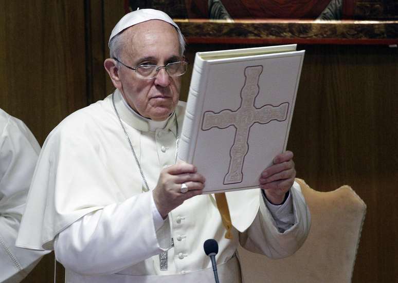<p>Papa Francisco levanta o livro dos evangelhos ao conduzir a conferência italiana de bispos (CEI), no Vaticano, em 19 de maio</p>