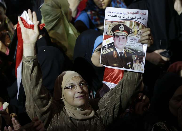 <p>Cidadã do Egito segura um cartaz do general Abdul Fatah al-Sisi, durante um comício, no Cairo, em 2013</p>
