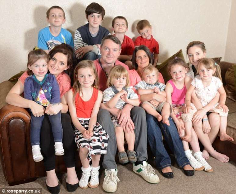 Nem todos os membros da família estão na imagem; Sue e o marido, ao centro, têm 16 filhos e esperam outro