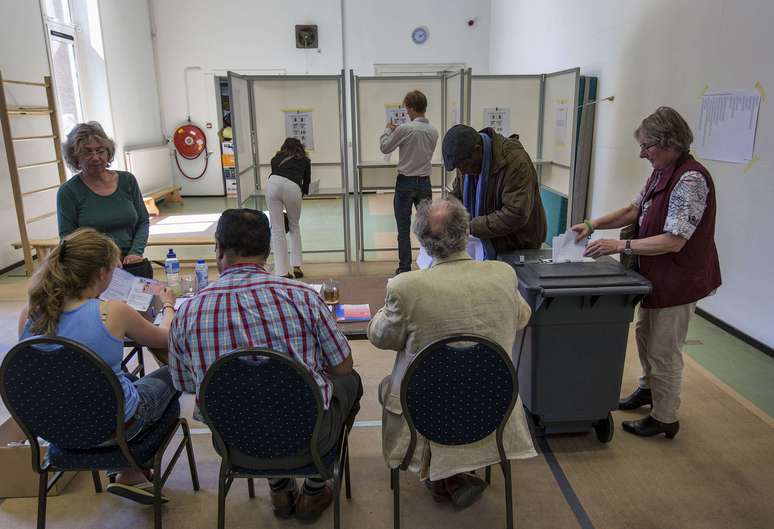 <p>Uma mulher deposita seu voto em uma urna no ginásio de uma escola primária usada como local de votação durante as eleições para o Parlamento Europeu, em Utrecht, Paises Baixos, nesta quinta-feira, 22 de maio</p>