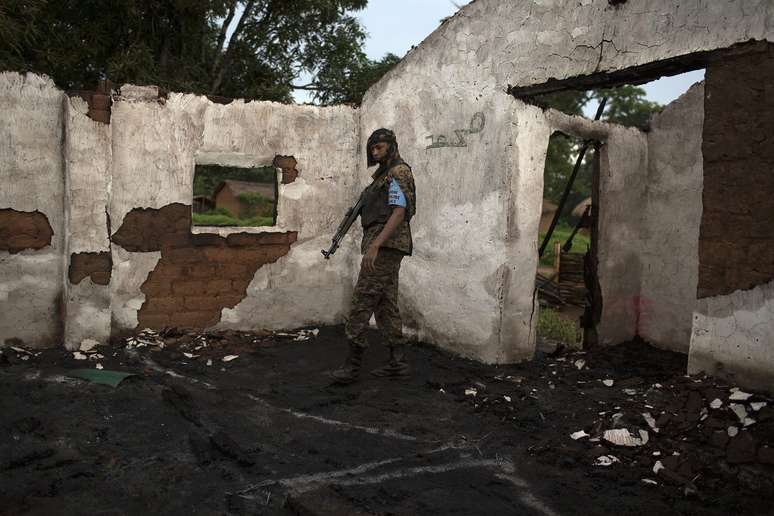 <p><strong>10 de maio de 2014 -</strong> soldado Seleka caminha por mesquista em ru&iacute;nas, ap&oacute;s um ataque a uma vila pr&oacute;xima &agrave; cidade de Bambari</p>