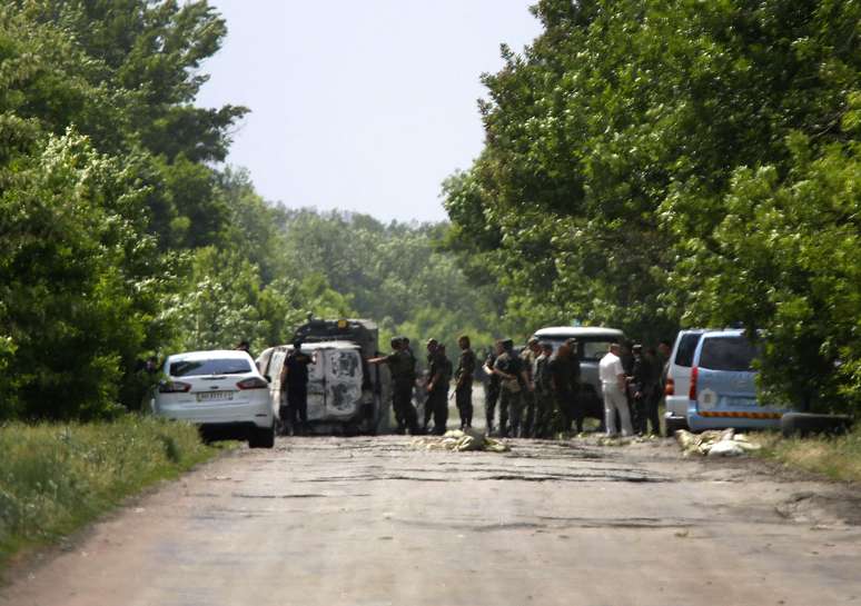 <p>Soldados ucranianos examinam área onde rebeldes pró-russos mataram militares ucranianos na periferia da cidade ucraniana de Volnovakha, ao sul de Donetsk , em 22 de maio</p>