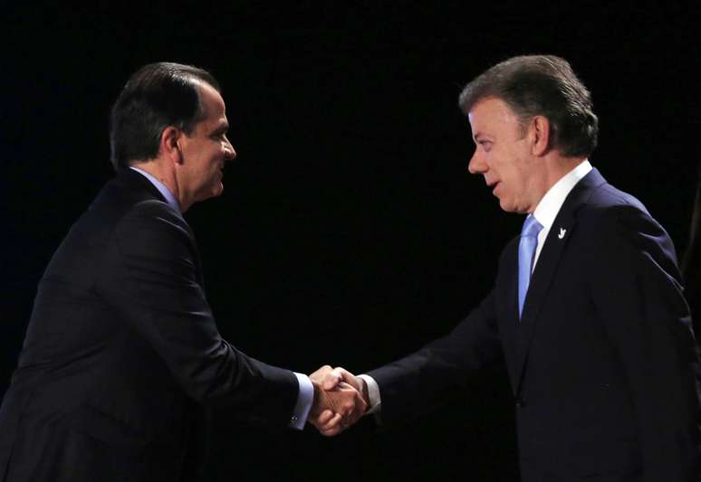 <p>Óscar Iván Zuluaga e Juan Manuel Santos se cumprimentam ao final de debate televisionado, em 22 de maio</p>