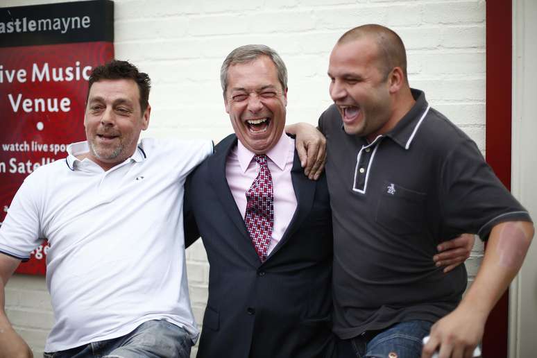 <p>O líder do Partido da Independência do Reino Unido, Nigel Farage (ao centro), comemora com simpatizantes durante uma parada em um pub a eleição de alguns conselheiros, em Basildon, no sul da Inglaterra, em 23 de maio</p>