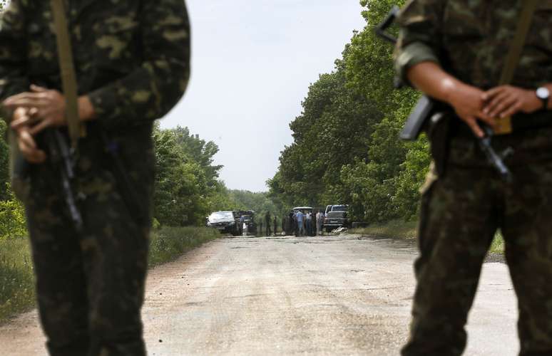 <p>Soldados ucranianos protegem área onde rebeldes pró-russos mataramcerca de 18 militares militares ucranianos na periferia da cidade ucraniana de Volnovakha, ao sul de Donetsk, em 22 de maio</p>