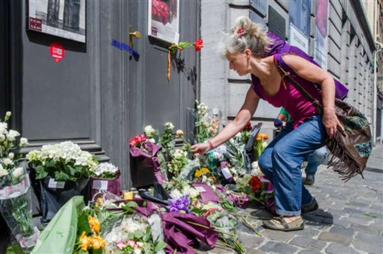 Mulher deposita flores no local onde ocorreu o atentado, em Bruxelas