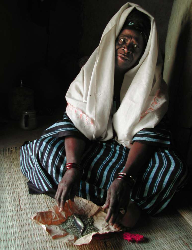 <p>Mariam Coulibaly exibe as ferramentas que utilizava para realizar a mutilação de meninas em seu país: uma faca que era de sua mãe e ervas, para curar as feridas, em Salemata, sudeste do Senegal, em janeiro de 2003</p>