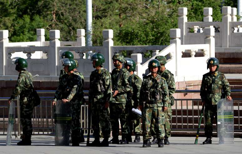 Polícia paramilitar da China faz guarda em mercado de Urimq, na região de Xinjiang, em 24 de maio 