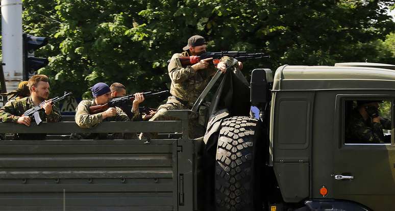 <p>Um caminhão militar com homens armados pró-russos passa por um posto de polícia, indo em direção ao aeroporto da cidade ucraniana de Donetsk, no leste, em 26 de maio</p>