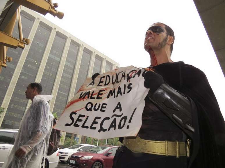 <p>"Batman" segura cartaz manchado de sangue após ser agredido</p>