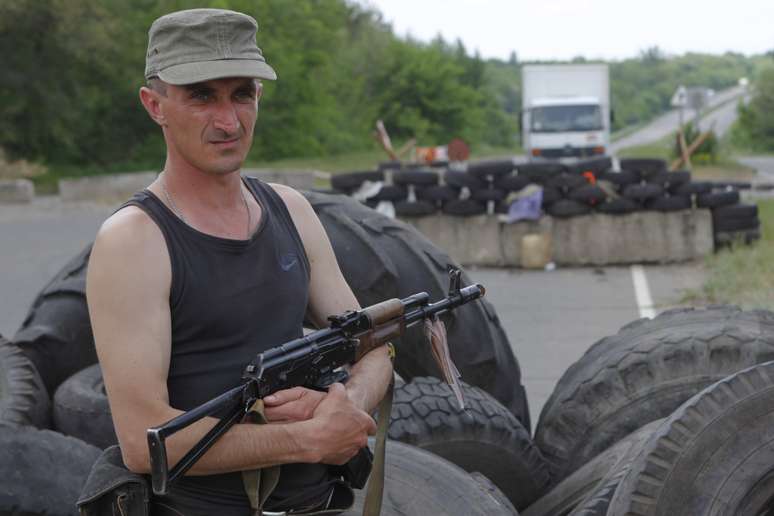 <p>Rebelde pró-russo posa para foto em frente a barricada montada em Lugansk, no leste ucraniano</p>