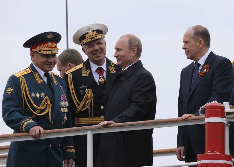 <p>O presidente russo, Vladimir Putin (direita), o ministro da Defesa, Sergei Shoigu (esquerda), o comandante da Frota do Mar Negro, Vice-Almirante Aleksander Vitko ,&nbsp;e o Diretor do Servi&ccedil;o Federal de Seguran&ccedil;a da R&uacute;ssia (FSB), Alexander Bortnikov, em Sevastopol no dia 9 de maio</p>