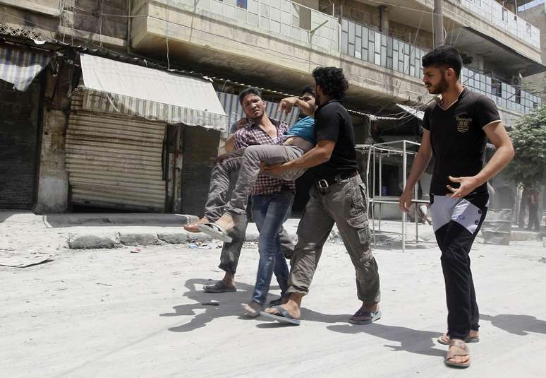 <p>Civis socorrem homem ferido durante bombardeios do regime de Assad a bairro de Aleppo, em 29 de maio</p>