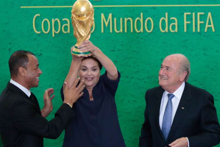<p>Com Cafu e Blatter Dilma já levantou o troféu ao "receber" oficialmente a Copa do Mundo 2014</p>