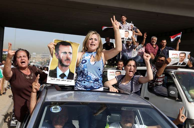 <p>Sírios que vivem no Líbano entoam hinos e carregam retratos de Bashar al-Assad enquanto dirigem em direção a embaixada síria em Beirute, em 28 de maio</p><p> </p>