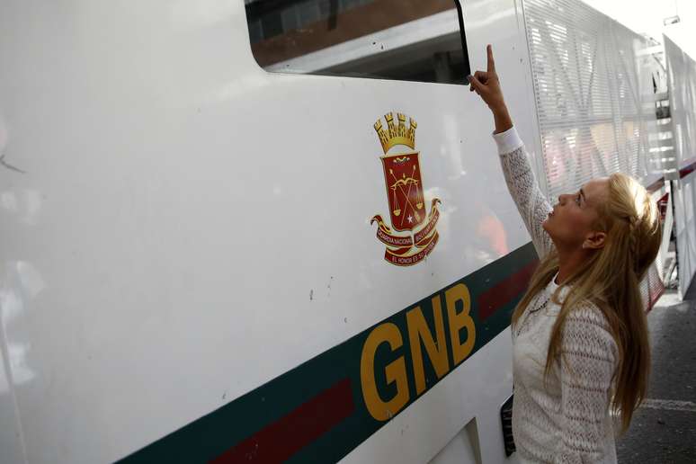 <p>Lilian Tintori, esposa do l&iacute;der opositor preso Leopoldo L&oacute;pez, aponta para o caminh&atilde;o blindado da&nbsp;Guarda&nbsp;Nacional&nbsp;enquanto espera para assistir o julgamento de seu marido no tribunal em Caracas, em&nbsp;2 de junho</p>