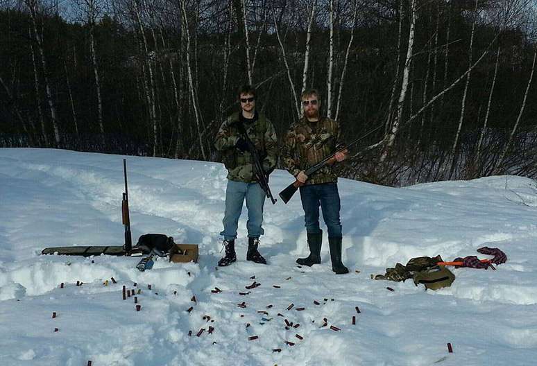 Foto do perfil do principal suspeito de um tiroteio no Canadá traz dois homens com armas em uma área arborizada