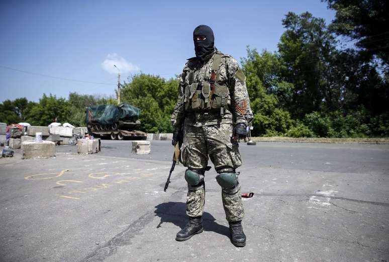 <p>Separatistas do leste afirmam que controlam entre 150 e 200 quil&ocirc;metros da fronteira entre Ucr&acirc;nia e R&uacute;ssia. Na foto, um&nbsp;rebelde pr&oacute;-R&uacute;ssia&nbsp;monta&nbsp;guarda em um posto de controle no leste da cidade ucraniana de Kramatorsk, em 4 de junho</p>