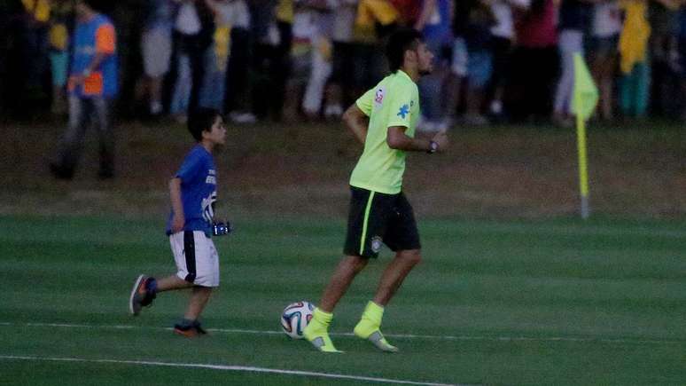 <p>Menino corre ao lado de Neymar após ter sido "resgatado" pelo craque do Barcelona</p>