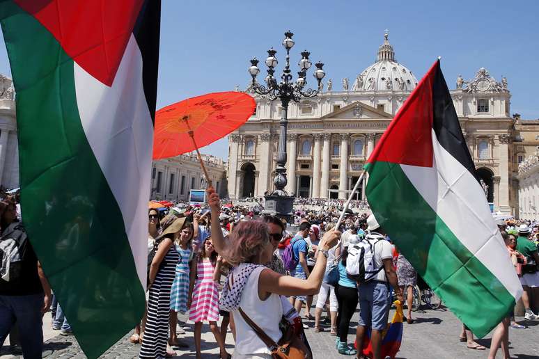 Fiéis levantam bandeiras palestinas durante oração do Papa neste domingo no Vaticano